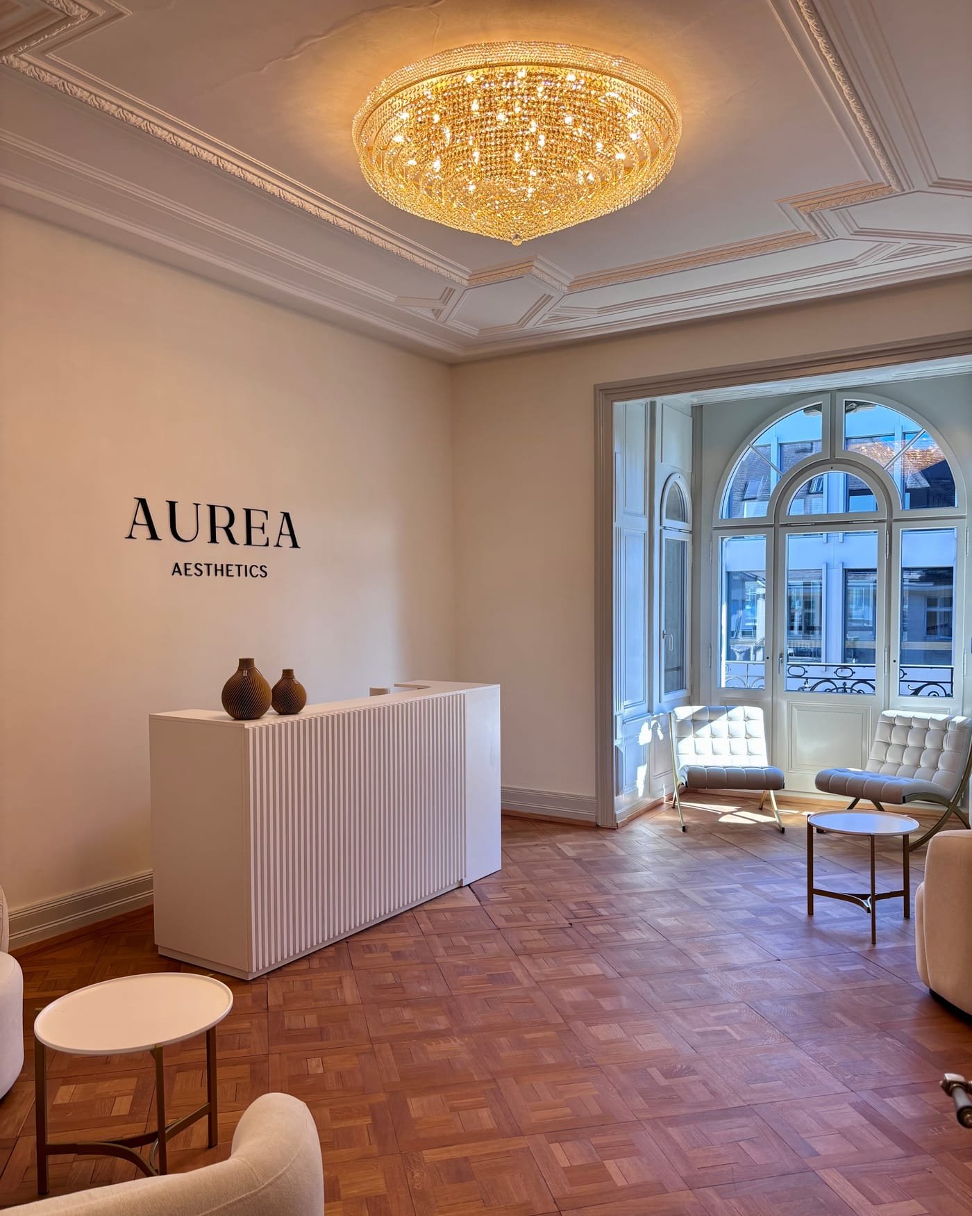 Blick in den Empfang der Klinik mit Kronleuchter und AUREA-Schriftzug